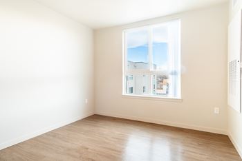 Empty room with a large window overlooking a residential area.
